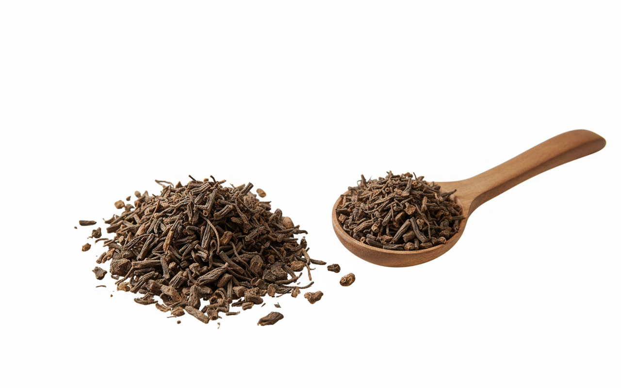 Valerian root on a white background with a wooden spoon filled with herbs.